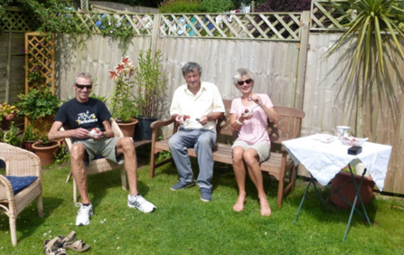 Three people having tea in their garden
