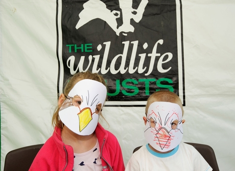 Children posing in their wildlife masks that they've coloured in themselves