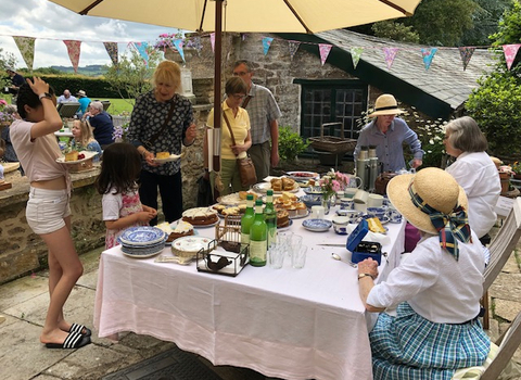 Guests enjoying tea and cake at a Wilder Open Garden