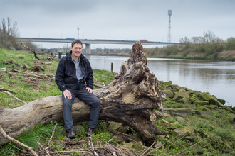 Jeremy sat on a log next to a river