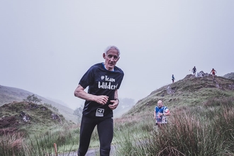 Team Wilder runner looking at the camera with hills in the background