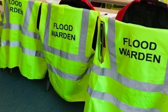 Hi-visibility jackets for Flood Wardens hanging on the backs of chairs