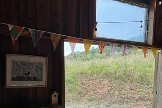 Converted barn with fabric bunting over a big open door looking over a nature reserve