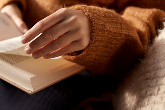 Reading a book in a cosy jumper