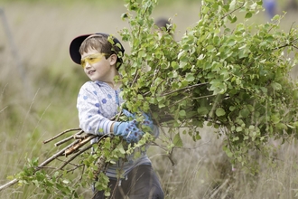 Local school children cut and collect growing tree saplings