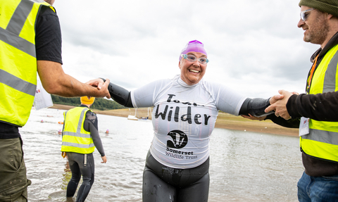 Team Wilder swimmer exiting the lake at the exmoor swim