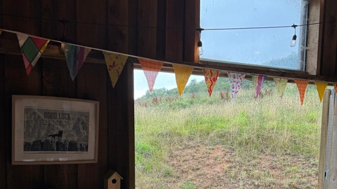 Converted barn with fabric bunting over a big open door looking over a nature reserve