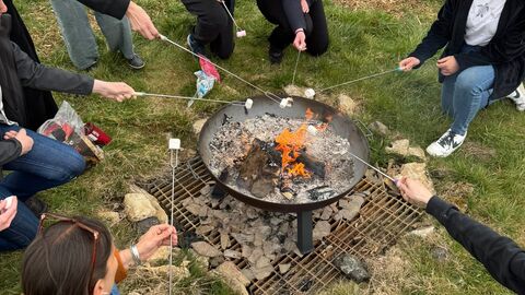 Image of Wilder Youth members toasting marshmallows over an open fire