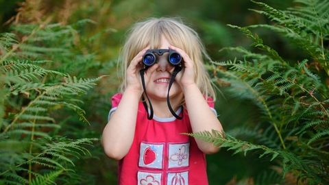 girl bird watching with binoculars