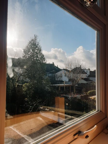 Views from a window with blue sky and clouds