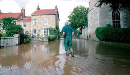 Man wading in flood water between houses when Pickering flooded in 2007