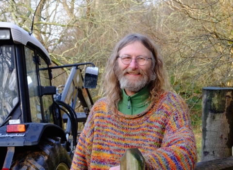 Rob standing next to a tractor holding wire