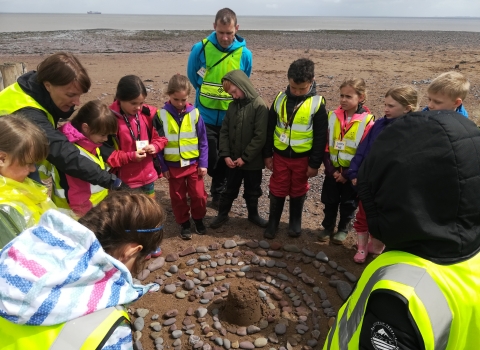 Children creating a mandala on Dunster Beach as part of the Wild Beach programme