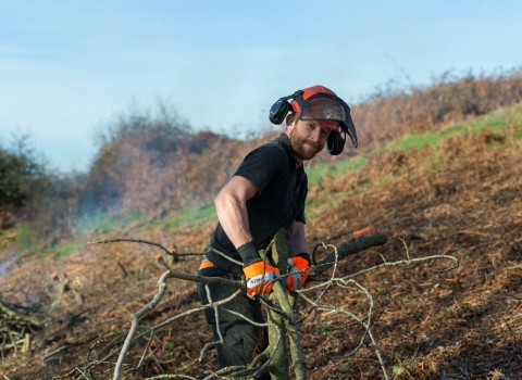 Man smiles as he clears clearing scrub