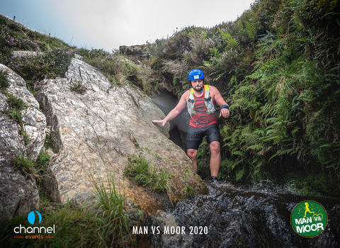 Man in helmet climbing out of a cave in Exmoor National Park