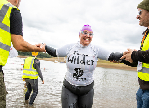 Team Wilder swimmer exiting the lake at the exmoor swim