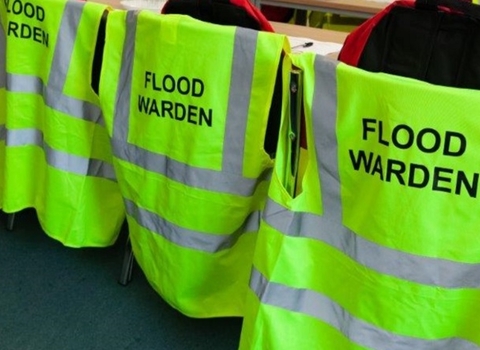 Hi-visibility jackets for Flood Wardens hanging on the backs of chairs