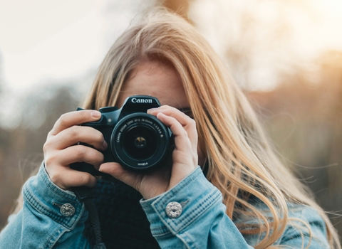 Image of a young girl holding a camera up to her eye