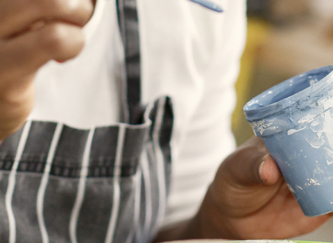 A lady painting pottery