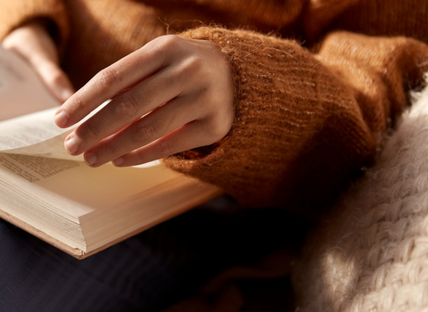 Reading a book in a cosy jumper